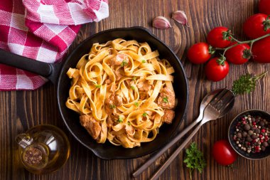 domates soslu makarna ve ahşap arka planda fesleğen.