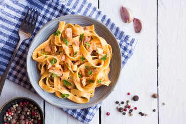 domates soslu makarna ve ahşap arka planda fesleğen yaprakları.