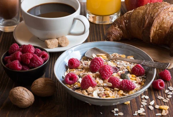 breakfast with berries, muesli and granola in bowl on wooden table background.