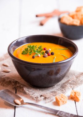 Kabak çorbası ve beyaz ahşap arka planda kızarmış ekmek.