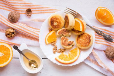 Beyaz tabakta portakallı ve fındıklı ev yapımı krepler.