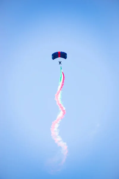 paraglider with smoke in colors of Italian flag flying in the sky