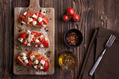 Domatesli bruschetta, peynir, domates, fesleğen ve zeytinyağı..