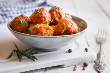 Domates soslu ev yapımı köfteler ve tahtada maydanoz.