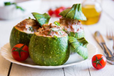 Beyaz tabakta sebzeli ve otlu fırında kabak.