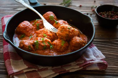 meatballs with tomato sauce in a pan on a wooden background. selective focus.
