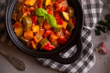 Siyah bir tencerede otlarla çeşitli sebzeler pişirdim.