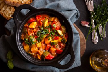 Siyah bir tencerede otlarla çeşitli sebzeler pişirdim.