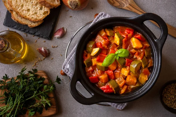 Siyah bir tencerede otlarla çeşitli sebzeler pişirdim.