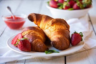 Çilekli kruvasan ve taze böğürtlen, lezzetli ve sağlıklı kahvaltı.