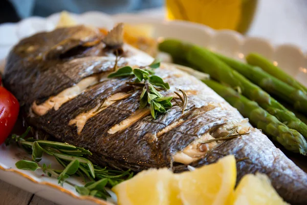 Roasted dorado fish with herbs and vegetables