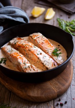 Kızarmış tavada krema soslu haşlanmış somon balığı.