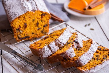 Ev yapımı balkabağı turtası. Tahtada krema ve portakal var.