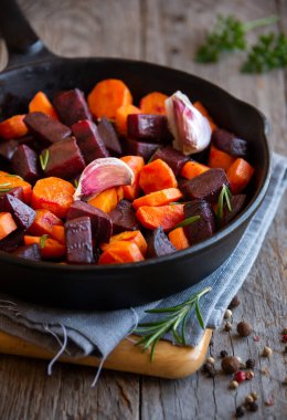 Tavada pancar kökü olan kızarmış havuç.