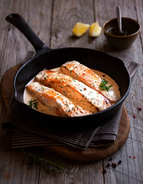 stewed salmon steaks with sauce in frying pan