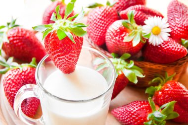 Beyaz arka planda cam bir kavanozda taze çilekler.