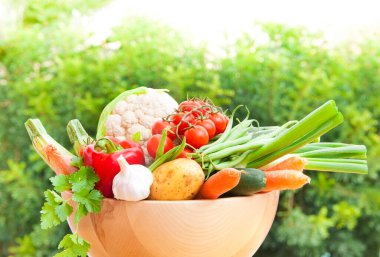 Tahta bir masada sepetteki taze sebzeler.