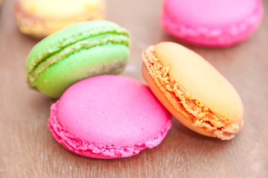 ahşap arka plan üzerinde renkli lezzetli macaroons