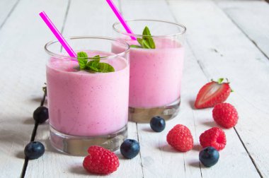 Böğürtlenli taze pembe smoothie ve ahşap bir arka planda nane..
