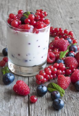 Ahşap zemin üzerinde böğürtlen ve ahududu bulunan ev yapımı yoğurt. seçici odak.