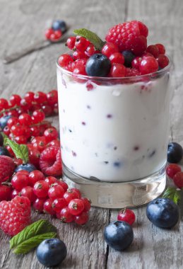 Böğürtlenli yoğurt ve ahşap arka planda yaban mersini.