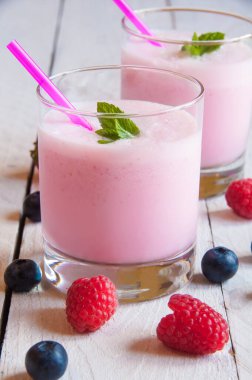 Bir bardak taze ahududu püresi ve ahşap arka planda böğürtlen.