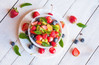 Çilekli taze yaz meyveleri ve ahşap arka planda nane şekeri. en üstteki görünüm.