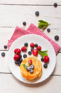 Ahududulu krep ve beyaz tabakta yaban mersini.