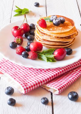 Böğürtlenli krep ve beyaz tabakta yaban mersini yığını