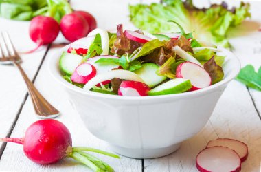 Taze sebzeli salata ve beyaz tabakta turp.