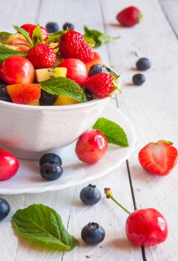 Tahta arka planda taze çilek ve nane yaprakları.