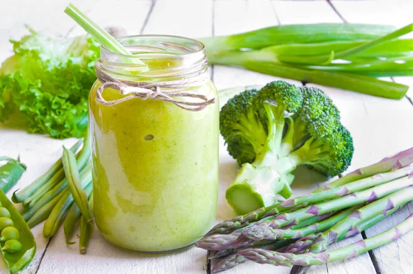 Beyaz ahşap arka planda taze sebzeli yeşil smoothie.