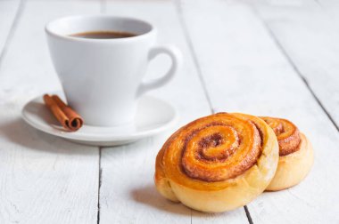 Tarçınlı kahve ve beyaz ahşap arka planda krema.