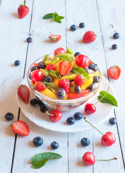 Böğürtlenli taze meyve salatası ve ahşap arka planda yabanmersini.