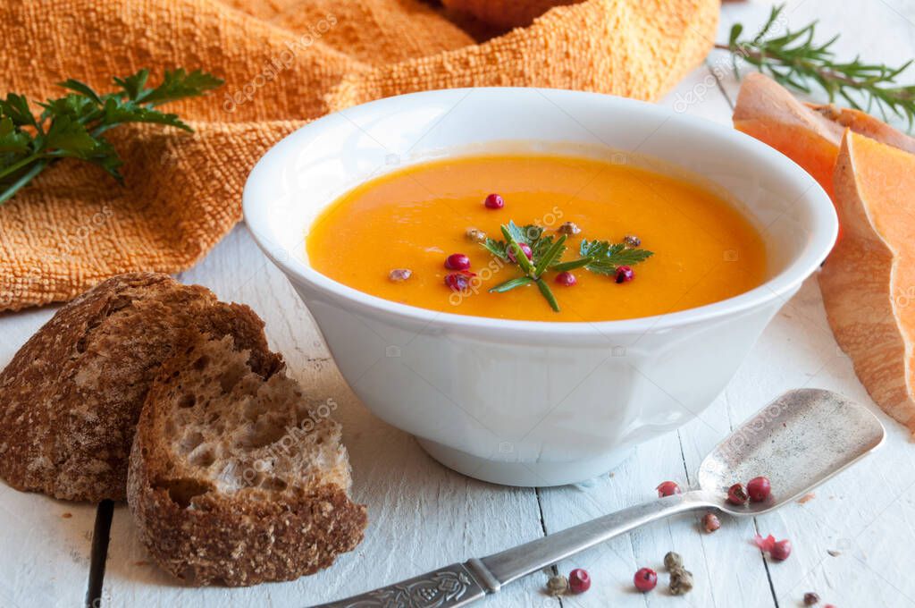 pumpkin soup with croutons and spices on wooden background
