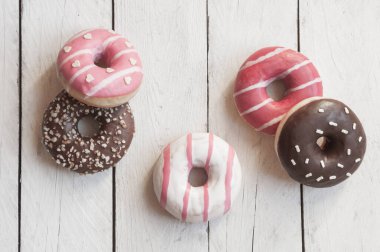 Pembe çörekler ve ahşap arka planda çikolata kreması. 