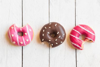 Beyaz ahşap arka planda pembe kremalı çörekler