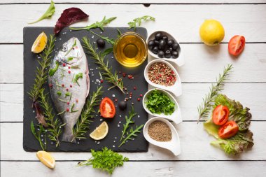 Ahşap arka planda sebzeli ve baharatlı çiğ somon filetosu.