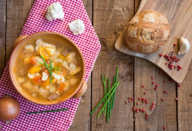 Ahşap arka planda tavuk ve sebzeli çorba.