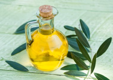 Ahşap bir arka planda cam bir şişede zeytin yağı
