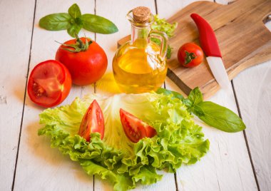 Tahta arka planda taze domates ve fesleğen.