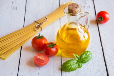 Domatesli İtalyan makarnası ve ahşap arka planda fesleğen.