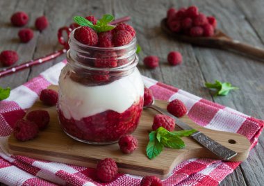 Mason kavanozunda kremalı taze ahududu.