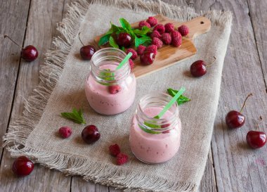 Taze böğürtlenli ev yapımı yoğurt ve ahşap arka planda nane. seçici odak.