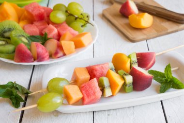 Beyaz ahşap zemin üzerine taze meyve salatası