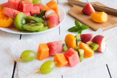 Beyaz ahşap zemin üzerine taze meyve salatası