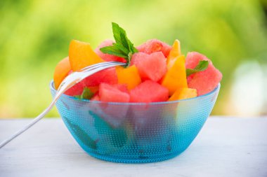 Taze şeftali dilimleri ve kâsede karpuz.