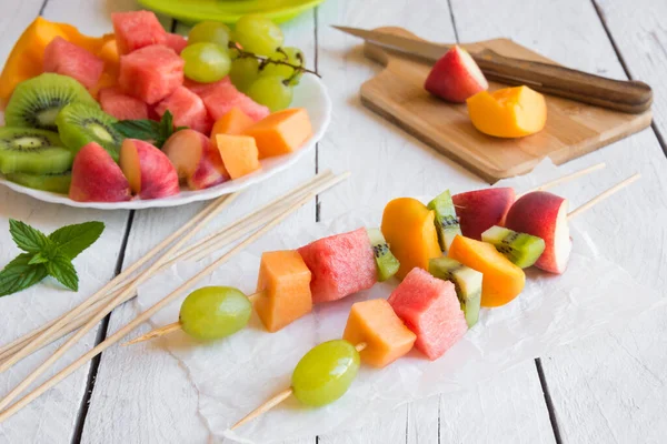 Beyaz ahşap zemin üzerine taze meyve salatası