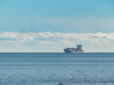 Galiçya 'da baharda ufuk çizgisinde konteynır taşıyan yük gemisi taşıyan deniz pelerini.