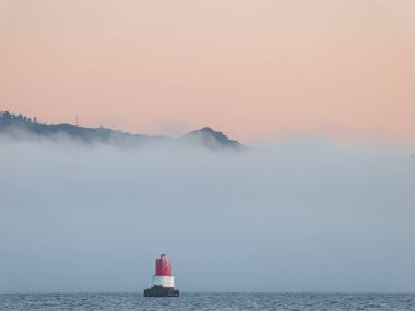 Denizdeki deniz feneri Yazın bir sis yığınının yanında